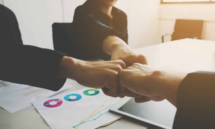 Project team of businessman and businesswoman fist bumping teamwork together.